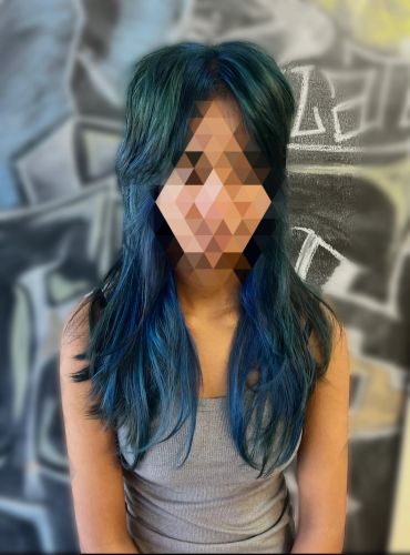 Person with long blue hair and gray tank top.