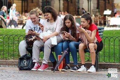 Girls with cellphones on a bench