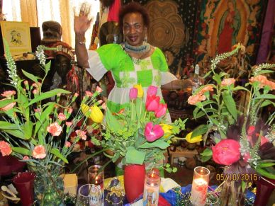 Woman happily waving behind colorful flowers and candles.
