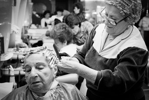 Elderly woman getting a perm at a salon.