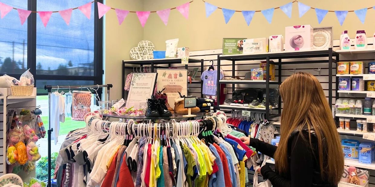 Woman shopping for baby clothes and items in a store.