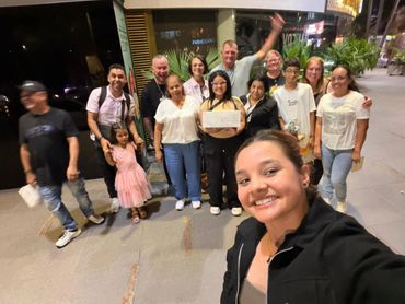 A group of people posing for a nighttime selfie outdoors.
