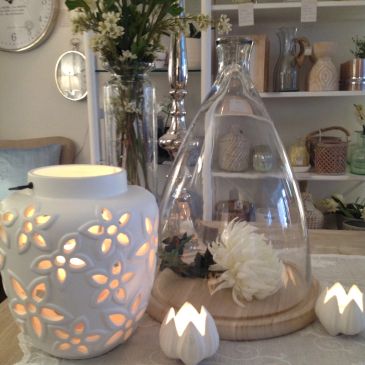 Decorative white candle holders and flowers on a table.