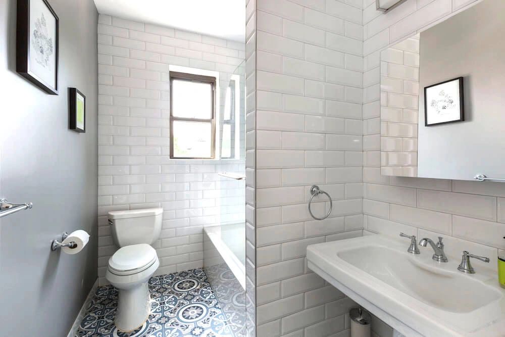 Renovated NYC bathroom with white subway tile by Agalliu Contracting