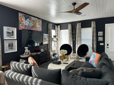 Modern living room with dark walls and unique round chairs.