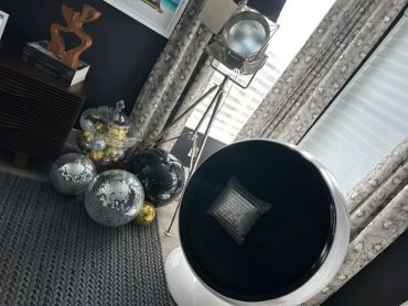 Modern black and white chair with disco balls and metallic decor.