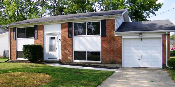 A single-story brick house with a white garage door and front door.