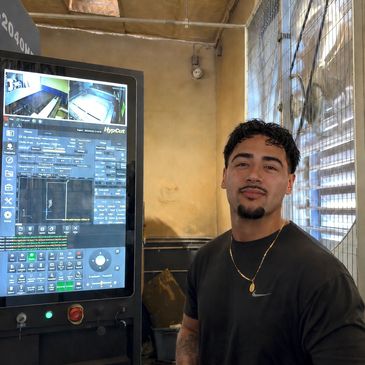 Man standing next to a large industrial touchscreen machine.