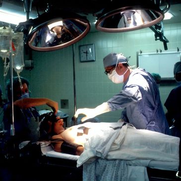 "Surgeon performing a complex surgery in an operating room. Nurse assisting with Surgery. 