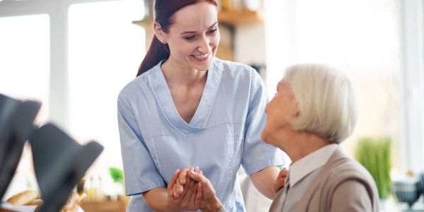 Carer holding elder's hand