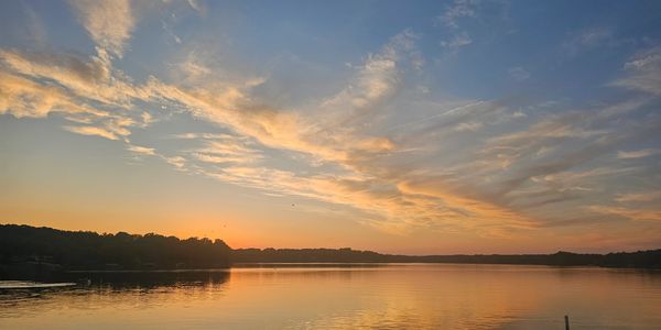 Calm lake at sunset with colorful sky.
