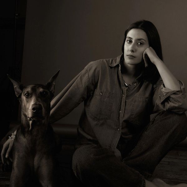Black and white portrait of a woman sitting with a dog.