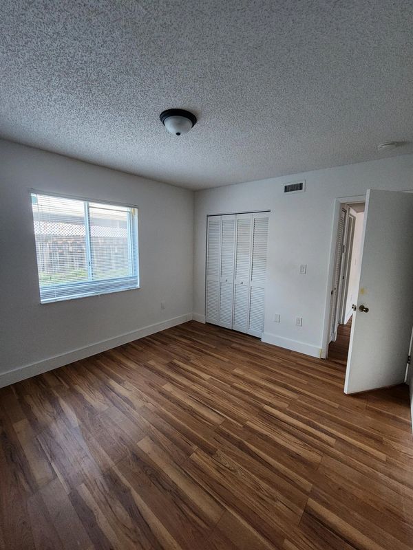 Empty room with wooden floor and white walls.