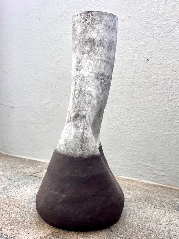 Two-tone ceramic vase with a rough texture and twisting shape.