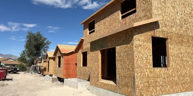 New houses under construction in a row on a sunny day.