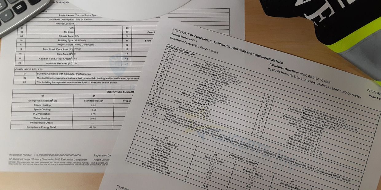 Two energy compliance reports on a desk with a calculator.