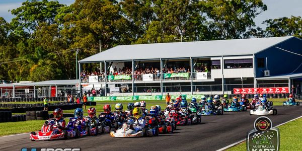 Go-kart race with many drivers competing on a track at an Australian Kart Championship event.