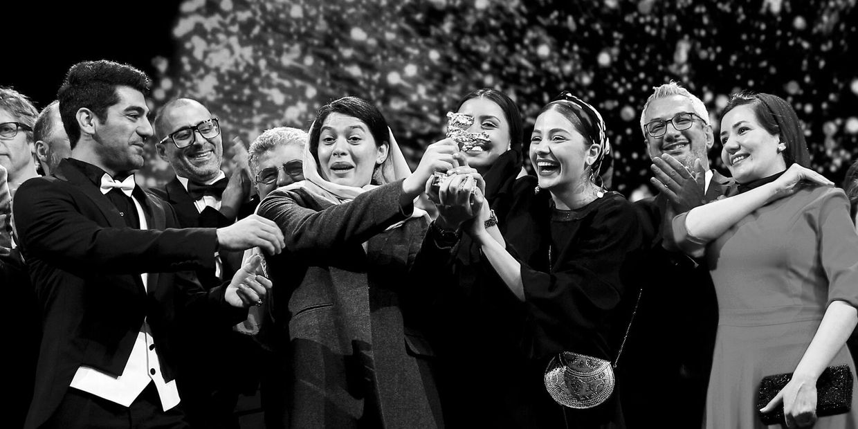 Group celebrates holding an award trophy.