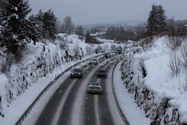 13.. Svinget riksvei med seks biler, på vinteren.