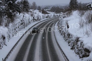 14. Svinget riksvei med en bil, på vinteren.