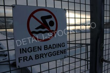 12. Vinter på båtbrygge med varselsskilt.