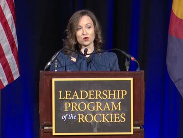 A woman speaks at a podium for the Leadership Program of the Rockies.