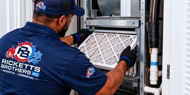 Technician replacing HVAC air filter.