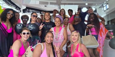 Group of women enjoying a boat party, dressed in pink and casual summer attire.