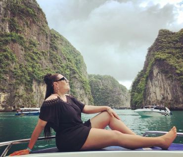 Woman relaxing on a boat in a scenic bay.