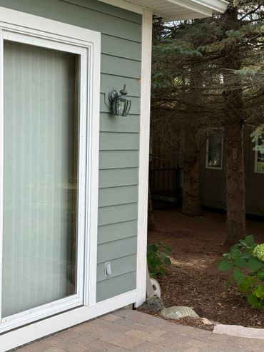 House corner with sliding glass door and outdoor light fixture.