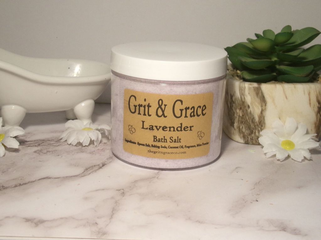 Lavender bath salt jar with decorative flowers and a succulent plant.