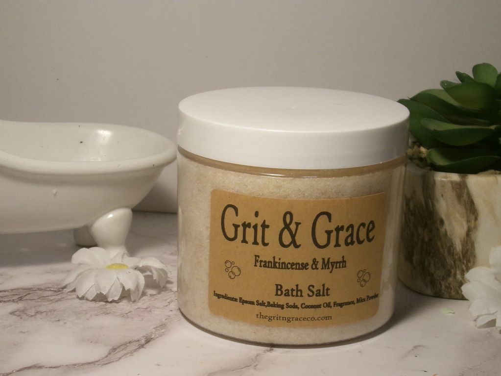 Grit &amp; Grace Frankincense &amp; Myrrh bath salt jar on a marble surface.
