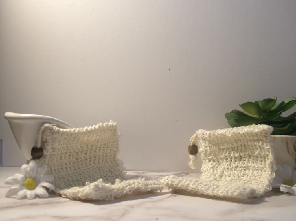 Two handmade crocheted soap savers with wooden beads and decorative flowers.