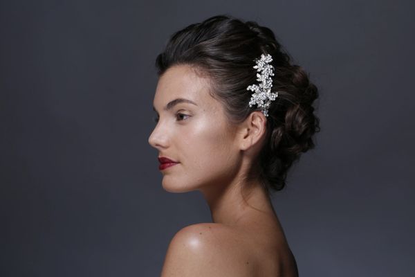 Model has a natural makeup look with a striking red lipstick, and her skin has a radiant glow. 