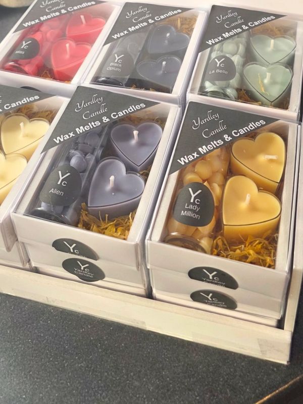 Assorted heart-shaped wax melts and candles in clear boxes.