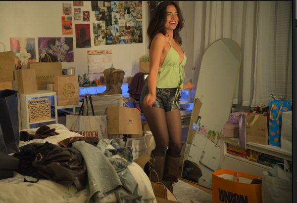 Woman dancing joyfully in a bedroom.