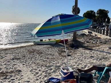 beach umbrella on the sand in tampa bay beach. www.whatsuppaddlesports.com