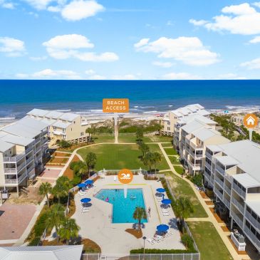 Beachfront resort with pool and direct beach access under a blue sky.