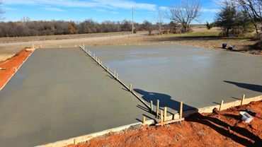 Freshly poured concrete slab curing outdoors on a sunny day.