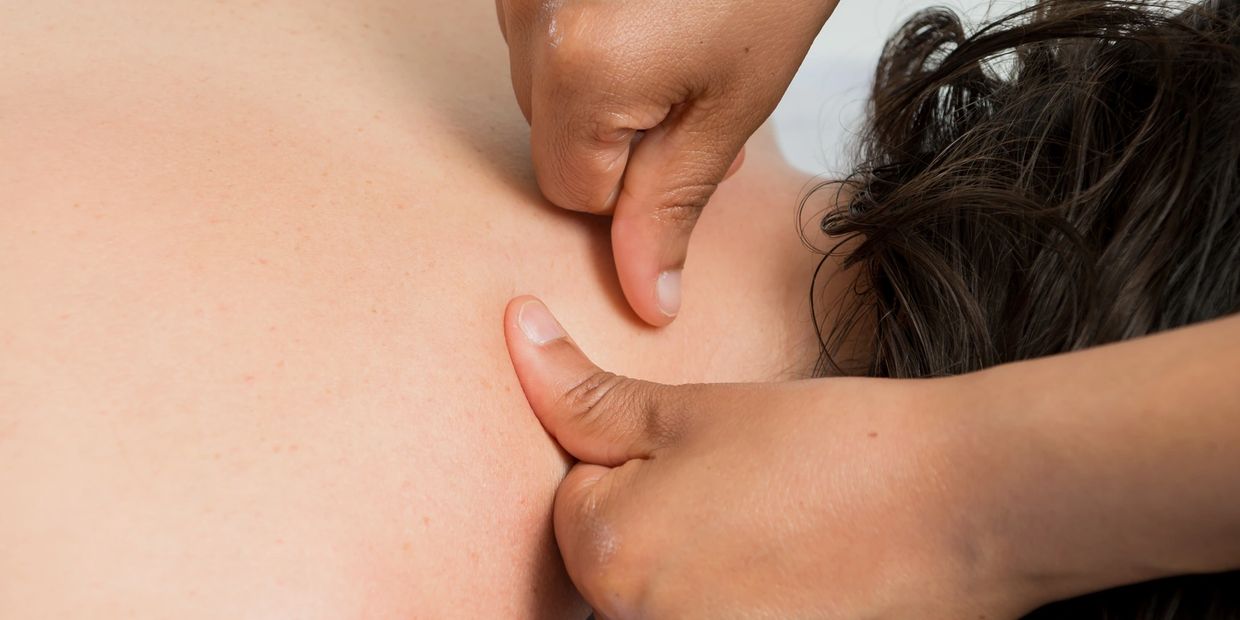 Massage therapist performing trigger point therapy on a client's back.
