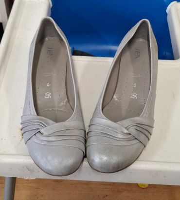Pair of light gray women's ballet flats with pleated design on toes.