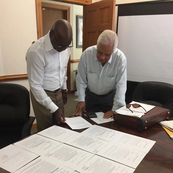 Two men reviewing documents at a table.