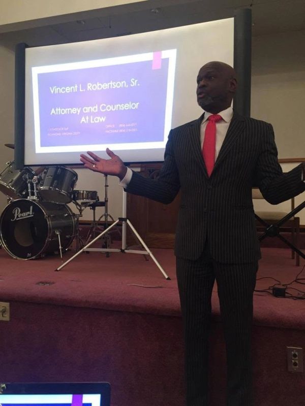 Man giving a presentation in front of a projector screen.