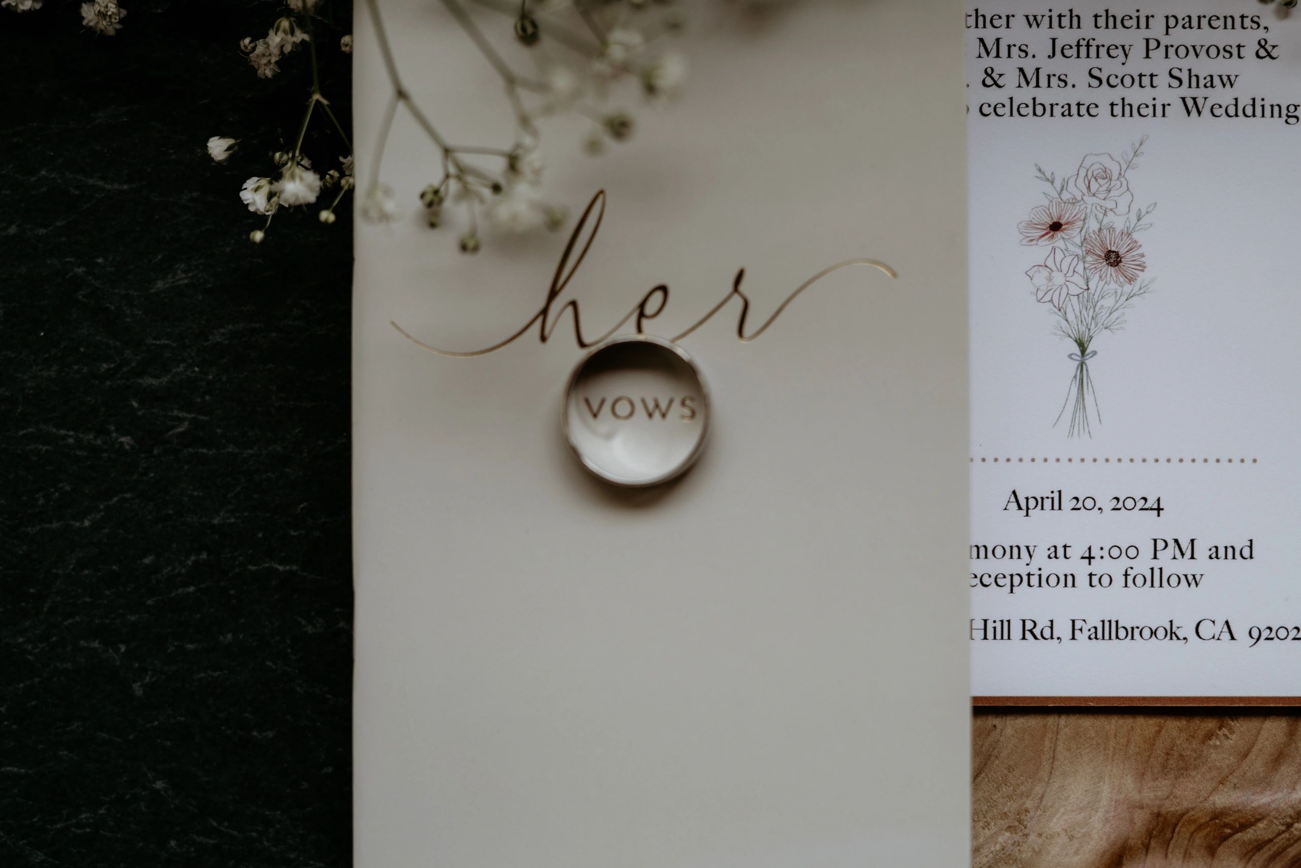 Wedding vow booklet with a ring casting a shadow on the word "vows".