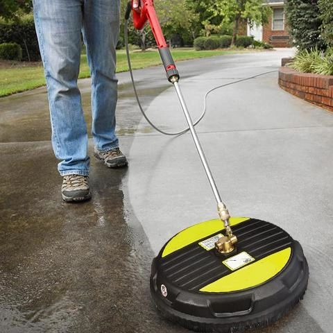 Person using a surface cleaner to pressure wash a driveway.