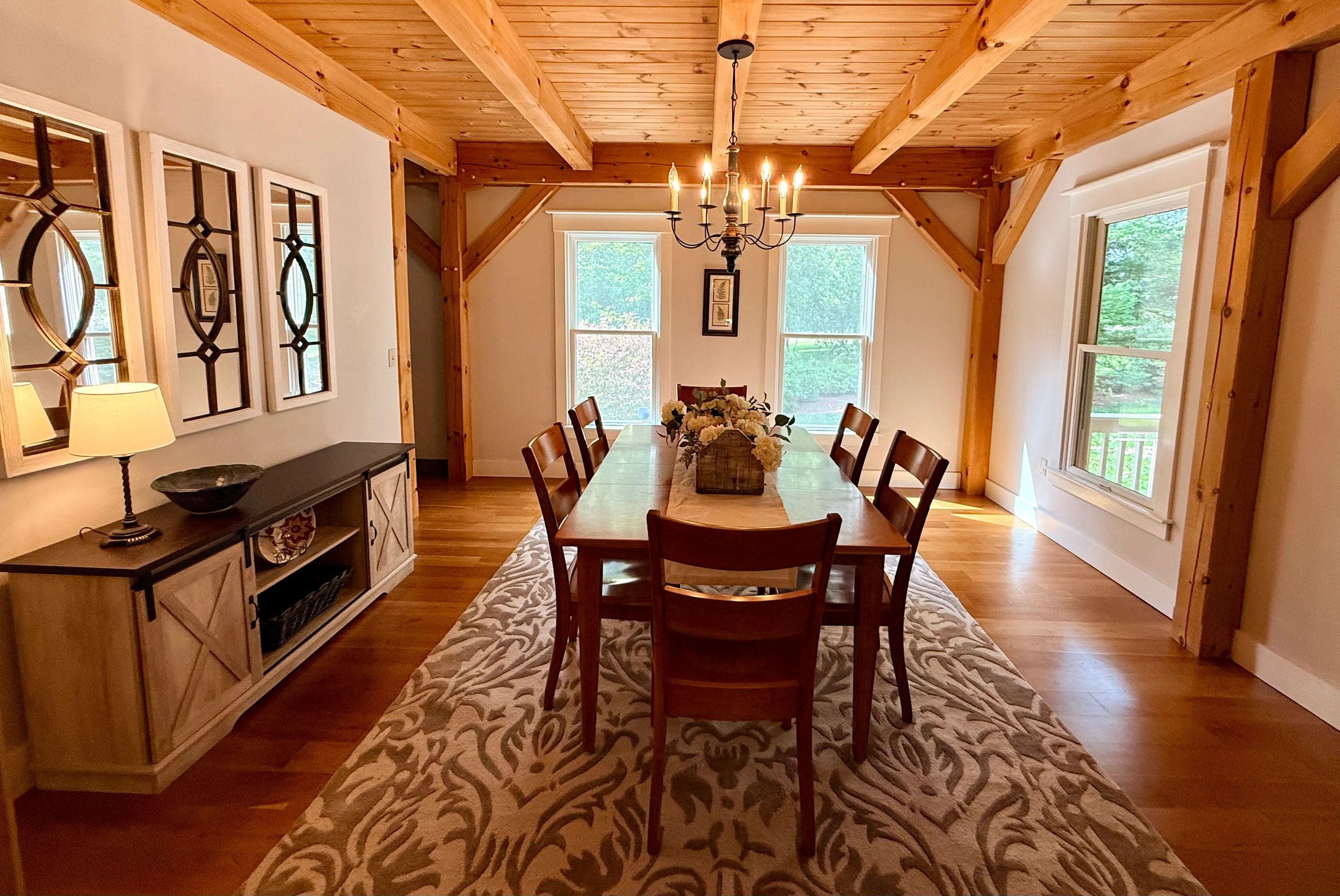 Rustic dining room with wooden beams and chandelier.