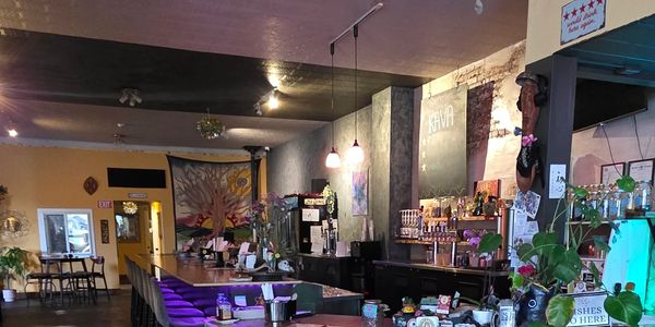 Cozy bar with purple lighting and seating at Golden Hour Tea