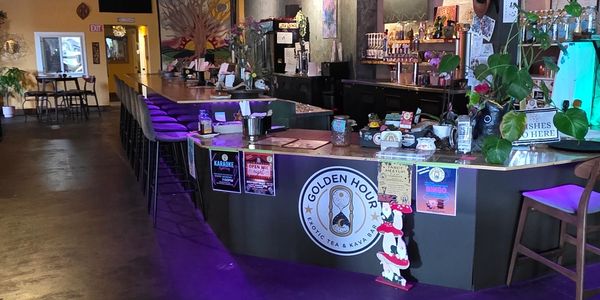 Cozy bar with purple lighting and seating at Golden Hour Coffee Tea &amp; Kava Bar.