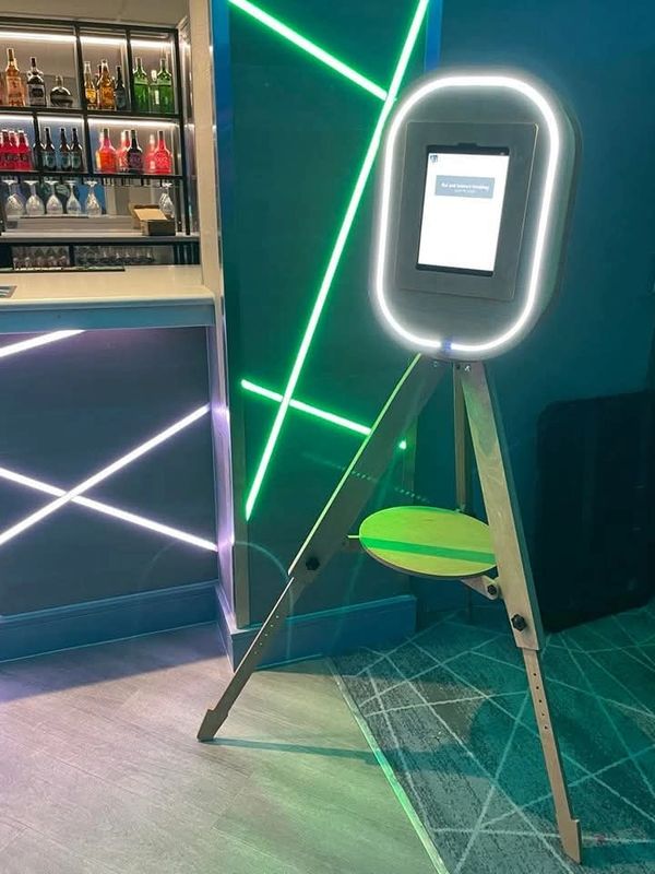 A modern photo booth with illuminated ring light in a stylish bar setting.