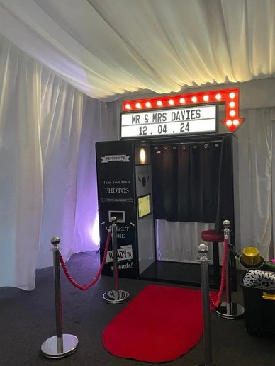 Photo booth setup with red carpet and sign for Mr & Mrs Davies' event on 12.04.24.